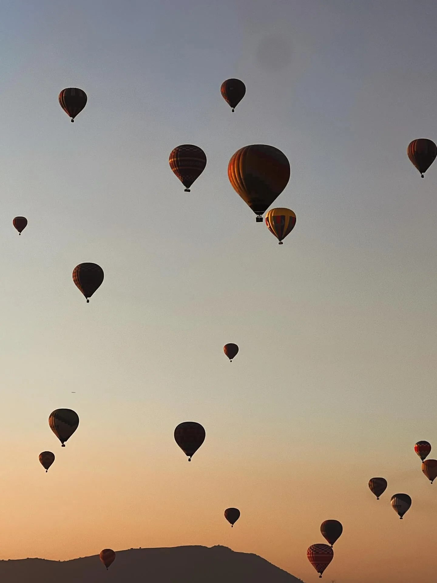 A sky full of hot air balloons over the Teotihuacan valley at dawn