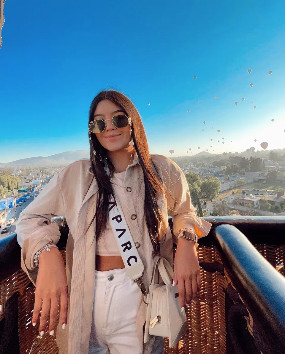 A passenger standing in the balloon basket with the Teotihuacan valley spread out below