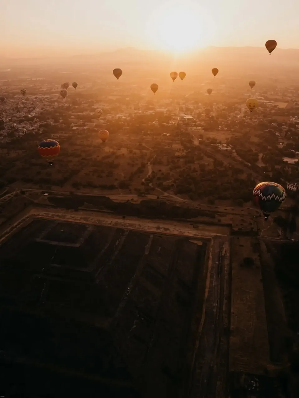 Sunrise light spreading across the ruins of Teotihuacan, seen from the air