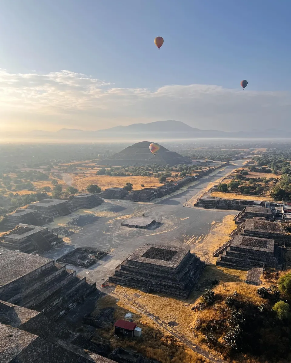 The Teotihuacan pyramids in morning mist, seen from a hot air balloon