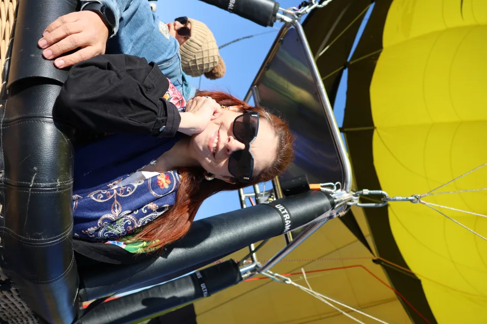 Mujer relajada en la canastilla en vuelo bajo una cúpula amarilla