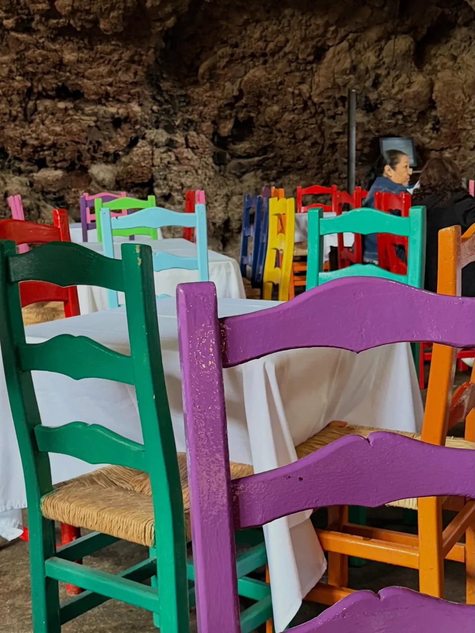 Handmade chairs in bright colours in the dining room at La Gruta Teotihuacan