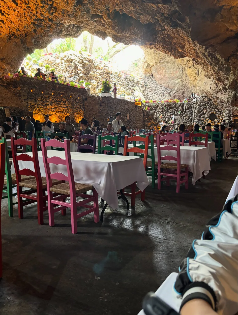 Red chairs and white linen against the rock wall at La Gruta Teotihuacan