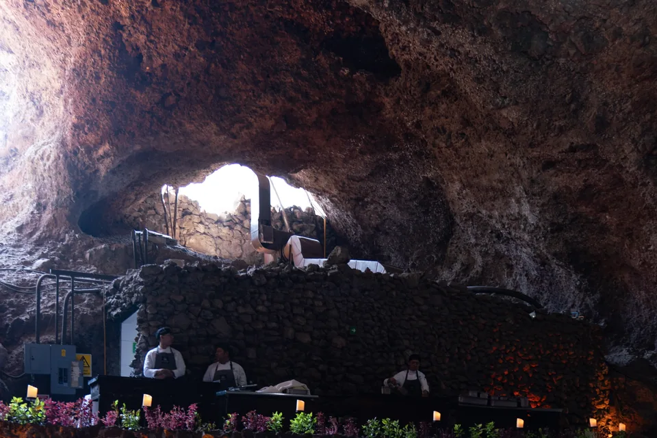 The rock arch of La Gruta seen from inside, with diners at their tables below