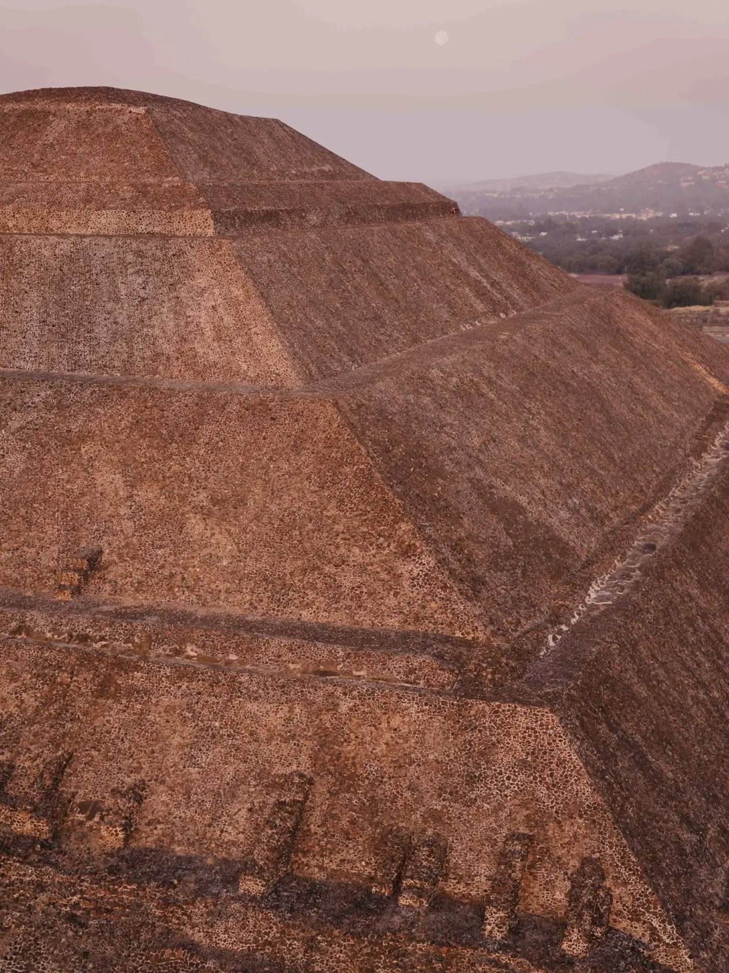 Close view of the Pyramid of the Sun from a balloon basket, its stepped stone faces lit from the side